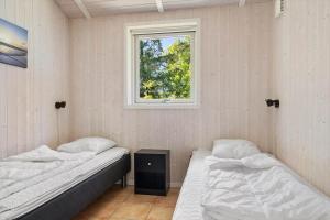 two beds in a room with a window at 0390-Romo-Lyngvejen-45-A in Høm