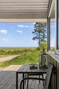 a table and chairs on a porch with a view of the ocean at 0390-Romo-Lyngvejen-45-A in Høm
