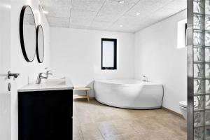 a white bathroom with a tub and a sink at 0374-Romo-Vestergade-337 in Høm +18 photos
