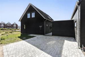 a black house with a brick driveway at 0374-Romo-Vestergade-337 in Høm