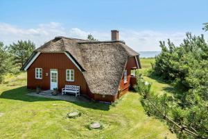 a small red house with a thatched roof at 0225-Romo-Kromosevej-22-A in Høm
