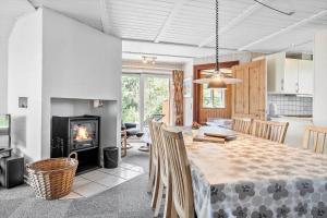 a kitchen and dining room with a table and a fireplace at 0225-Romo-Kromosevej-22-A in Høm