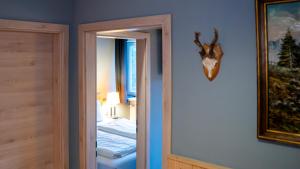 a room with a door with a deer head on the wall at Maiers Hotel in Bayerisch Eisenstein