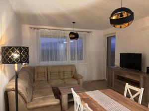 a living room with a couch and a table at Lima Apartment in Bernolákovo