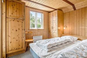 a bedroom with two beds in a room with wooden walls at 0225-Romo-Kromosevej-22-A in Høm