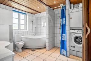 a bathroom with a toilet and a washing machine at 0225-Romo-Kromosevej-22-A in Høm +16 photos