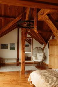a bedroom with a bed and a chair and wooden ceilings at Fawn Crest -Timber Frame Retreat, Firepit, 20 acre in Alfred Station