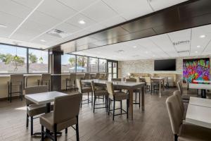 a dining room with tables and chairs and a tv at Best Western Plus Gilbert/Mesa in Mesa