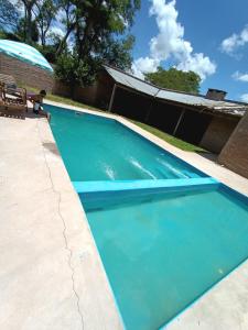 a large blue swimming pool with a person sitting next to it at Cabaña Doña Adela II in Paso de la Patria +6 photos