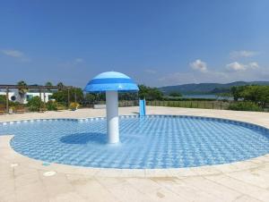 a small pool with a blue umbrella in it at 31 Exclusive Cabin with Private Jacuzzi, Beach in Tubará