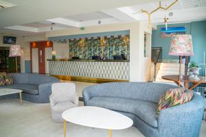 a living room with two couches and two tables at Hotel Baia in Cascais