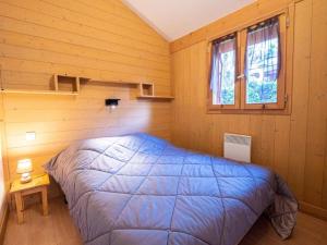 a bedroom with a bed in a wooden room at ZEcamping 3 étoiles animaux acceptés restaurant et Canoë Kayak in Aigueblanche