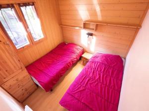 two beds in a small room with pink sheets at ZEcamping 3 étoiles animaux acceptés restaurant et Canoë Kayak in Aigueblanche