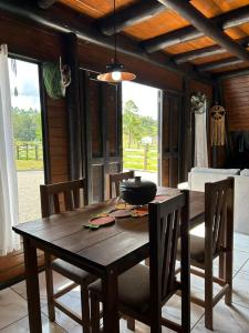 een houten tafel en stoelen in een kamer met een eetkamer bij Chalé Sossegado in Treviso