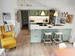 a kitchen with a blue and white counter and a yellow chair at 2801-Romo-Helmusager-4 in Høm