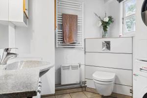 a white bathroom with a toilet and a sink at 2801-Romo-Helmusager-4 in Høm