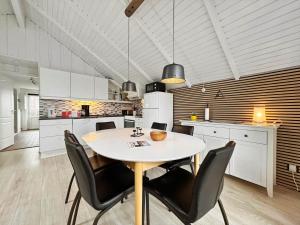 a kitchen with a table and chairs in a room at 0386-Romo-Vestergade-3-Ap-16 in Høm