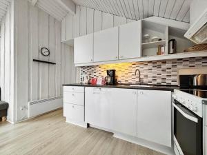 a white kitchen with white cabinets and appliances at 0386-Romo-Vestergade-3-Ap-16 in Høm +20 photos