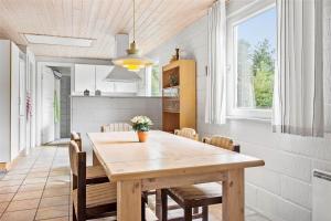 a kitchen and dining room with a wooden table and chairs at 0357-Romo-Sonderstrandvej-21 in Høm