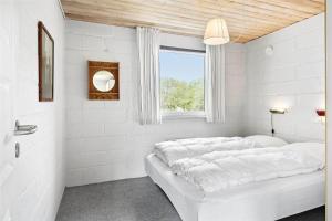 a white bed in a room with a window at 0357-Romo-Sonderstrandvej-21 in Høm