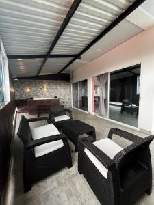 a living room with wicker chairs and tables at Hotel Boutique Primavera Beach in Necoclí
