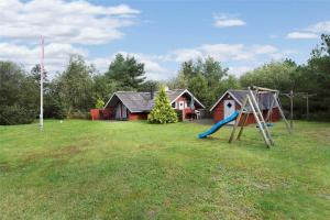 a yard with a playground with a slide and a house at 0146-Romo-Ejnar-Mikkelsensvej-16 in Høm