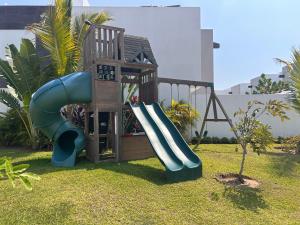 a playground with a slide in the grass at New Modern Acapulco Diamante House Getaway with Pool View and Beach Club in Acapulco