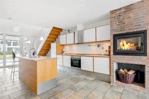 a kitchen with a fireplace and a stove at 1356-Romo-Blaklokkevej-356 in Høm