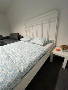 a bedroom with a white bed and a couch at COliving RD6 in Ljubljana