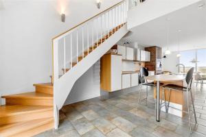 a kitchen and dining room with a staircase in a house at 1356-Romo-Blaklokkevej-356 in Høm +17 photos