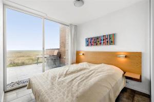 a bedroom with a bed and a large window at 1356-Romo-Blaklokkevej-356 in Høm