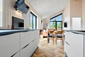 a kitchen with white cabinets and a living room at 0346-Romo-Vestergardsvaenget-11 in Høm