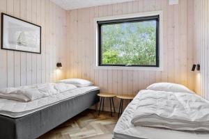 a bedroom with two beds and a window at 0346-Romo-Vestergardsvaenget-11 in Høm