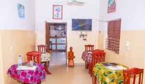 a dining room with two tables and chairs and a rainbow at Hotel Résidence Les Racines in Pira