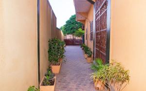 an alley with potted plants on the side of a building at Hotel Résidence Les Racines in Pira