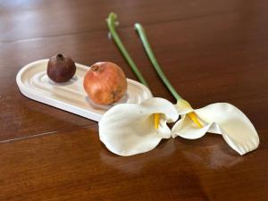 a plate with two fruits and a flower on a table at Αιθεροβάμων - Etherovamon in Areopoli
