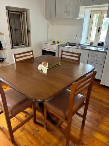 a kitchen with a wooden table with chairs and a dining room at Αιθεροβάμων - Etherovamon in Areopoli +18 photos