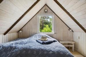 a bedroom with a bed with a book and a window at 0337-Romo-Kliren-1 in Høm