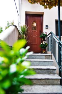 a wooden door with stairs in front of a house at Agria Lux Apartment - Pelion - Volos in Agria