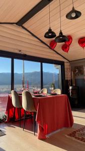 a dining room with a red table and chairs at Гойра in Dzembronya