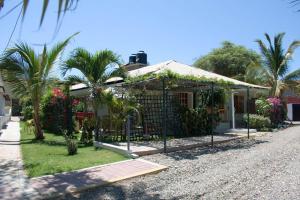 a house with a gate in front of it at Punta Sal Bungalows in Canoas de Punta Sal