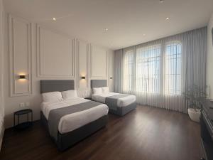 a hotel room with two beds and two windows at Vista Catedral Guadalajara - Self Check in in Guadalajara