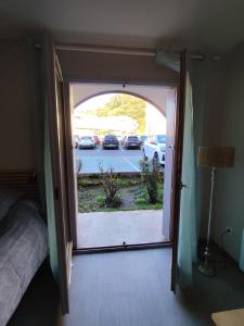 a door to a bedroom with a view of a parking lot at Studio Rénové - Le Verdale in Lamalou-les-Bains