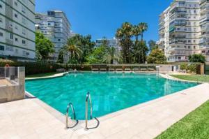 a swimming pool in a apartment with tall buildings at Apartamento ROMA in Torre del Mar