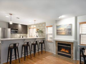 a kitchen with a fireplace and bar with stools at Greenlake urban lodge in Seattle +23 photos