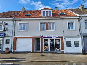 a white building with a store in front of it at Loft moderne dominant la ville in Wizernes