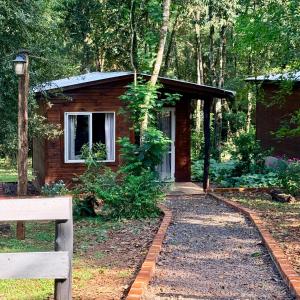 a log cabin with a pathway leading to a house at Cabañas Bruma de Monte in El Soberbio