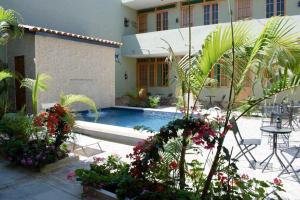 a courtyard with a pool and a table and flowers at Punta Sal Bungalows in Canoas de Punta Sal