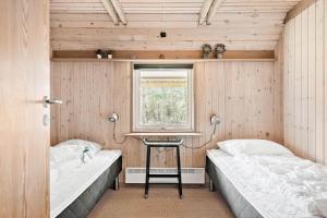 a small room with two beds and a window at 0314-Romo-Kliren-3 in Høm