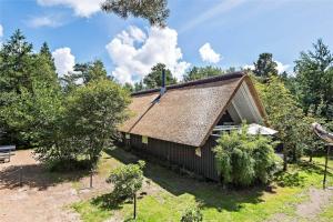 a small house with a thatched roof and trees at 0314-Romo-Kliren-3 in Høm
